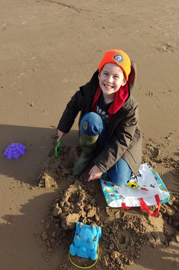 Aytron making a sandcastle on the beach